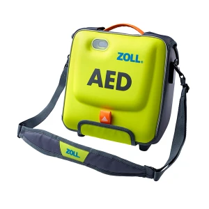 Grön defibrillator med ZOLL-märke, bärrem synlig.